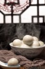Vista ravvicinata della ciotola con palline di riso glutinoso caldo sul tavolo — Foto stock