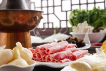 Close-up view of sliced meat, vegetables and copper hot pot, chafing dish concept — Stock Photo