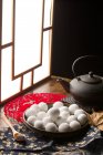 Traditional chinese glutinous rice balls on plate, teapot and spoon with sesame seeds — Stock Photo