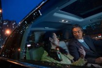 Glücklich asiatische Paar Reiten im Auto und Blick auf einander am Abend — Stockfoto