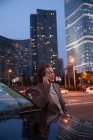 Glücklich reifer asiatischer Mann spricht per Smartphone und schaut weg in der Nacht Stadt — Stockfoto