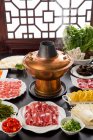 Panela quente de cobre, carne e legumes na mesa, conceito de prato de atrito — Fotografia de Stock