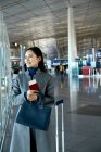 Bela jovem empresária segurando passaporte e bilhete no lounge do aeroporto — Fotografia de Stock