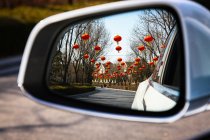 Auto rear view mirror with red lanterns reflection — Stock Photo