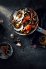 Вид зверху на різні смачні морепродукти в сковороді на сірій поверхні — стокове фото