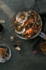Вид зверху на різні смачні морепродукти в сковороді на сірій поверхні — стокове фото