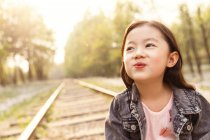 Ritratto adorabile asiatico bambino smorfia vicino ferrovia — Foto stock