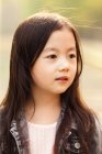 Portrait of adorable asian kid looking away outdoors — Stock Photo