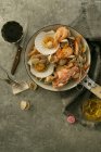 Draufsicht auf verschiedene köstliche Meeresfrüchte in der Pfanne auf grauer Oberfläche — Stockfoto
