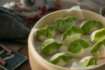 Vue rapprochée de délicieuses boulettes chinoises traditionnelles dans un bol sur la table — Photo de stock