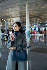 Bela jovem empresária segurando passaporte e bilhete no lounge do aeroporto — Fotografia de Stock