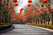 Традиционные красные китайские фонари висят над дорогой — стоковое фото