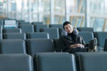 Молодой азиатский бизнесмен спит в аэропорту — стоковое фото