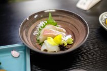 Nahaufnahme köstlicher Mahlzeiten auf braunem Teller, japanisches Kochkonzept — Stockfoto