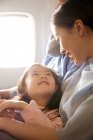 Famiglia felice con un bambino che viaggia in aereo, ragazza che guarda la madre — Foto stock