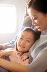Glückliche Familie mit einem Kind, das mit dem Flugzeug reist, Mädchen lächelt in die Kamera — Stockfoto