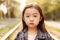 Портрет чарівної азіатської дитини, дивлячись на камеру на відкритому повітрі — стокове фото