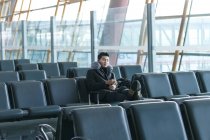Молодой азиатский бизнесмен спит в аэропорту — стоковое фото