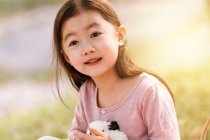 Adorabile asiatico bambino in abito holding coniglio a fiore campo — Foto stock