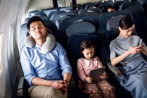 Famille heureuse avec un enfant voyageant en avion, vue grand angle — Photo de stock