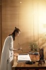 Vista lateral de jovem mulher asiática segurando escova e escrevendo caracteres chineses — Fotografia de Stock