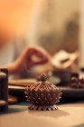 Крупним планом вид на ароматну традиційну азіатську прикрасу і жінка тримає сушений чай позаду, вибірковий фокус — стокове фото