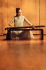Focused young asian woman playing traditional chinese guzheng instrument — Stock Photo
