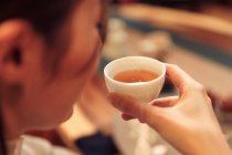 Вид крупним планом молода азіатська жінка тримає чашку чаю — стокове фото