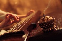 Cropped shot of woman playing traditional chinese guzheng instrument, selective focus — Stock Photo