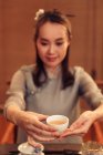 Hermosa sonriente joven asiático mujer celebración taza de té - foto de stock