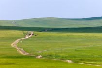 Bela paisagem com colinas verdes e estrada em pastagem, Mongólia Interior — Fotografia de Stock
