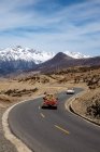 Vista ad alto angolo delle auto che guidano su strada asfaltata tra montagne panoramiche durante il giorno — Foto stock