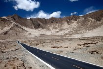 Empty asphalt road and scenic mountains in Tibet — Stock Photo