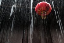 Низкий угол зрения на красный китайский фонарь, деревянная стена и дождь, Чжоучжуан, Куньшань, Цзянсу, Китай — стоковое фото