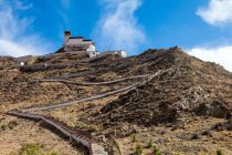 Vue à angle bas de la passerelle piétonne et la construction sur la montagne rocheuse au Tibet — Photo de stock