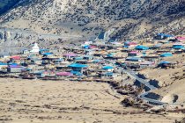 Vista de alto ângulo de casas perto da estrada e encosta da montanha no Tibete — Fotografia de Stock