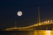 Pont illuminé et pleine lune dans le ciel nocturne, Shenzhen, Chine — Photo de stock