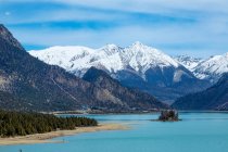 Beautiful landscape with snow-covered mountains, calm blue lake and green trees in Tibet — Stock Photo