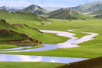Hermoso paisaje con montañas y pastizales Bayinbuluke en Xinjiang, China - foto de stock