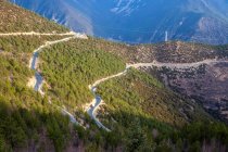 Aerial view of Sichuan-Tibet highway in scenic mountains with green vegetation — Stock Photo