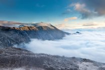 Горный пейзаж с заснеженными горами в облаках — стоковое фото