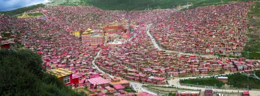 Vue aérienne des toits rouges des maisons dans le village situé dans la vallée, Sichuan, Chine — Photo de stock