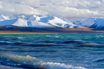 Belo lago ondulado e montanhas cobertas de neve no Tibete — Fotografia de Stock