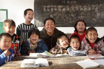 Profesora rural y alumnas chinas felices en el aula - foto de stock