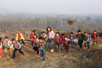 Молодая учительница и счастливые китайские школьники играют на открытом воздухе — стоковое фото