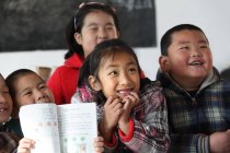 Cheerful asian school students studying in rural primary school — Stock Photo