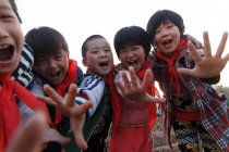 Happy rural chinese pupils laughing at camera outdoor — Stock Photo