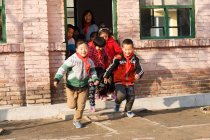 Rural chinese teacher and pupils in school and on yard — Stock Photo