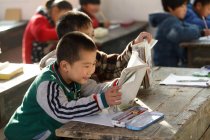 Studenti delle scuole cinesi che studiano con libri di testo nella scuola primaria rurale — Foto stock