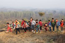 Jóvenes maestras y estudiantes de escuelas chinas jugando en el área rural - foto de stock